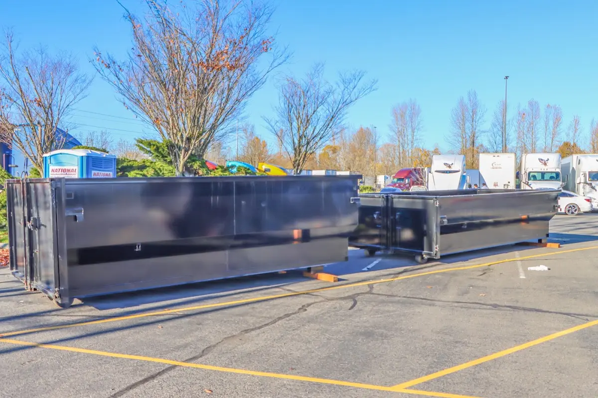 Professional dumpster rental service with roll-off container on residential driveway in Baxter